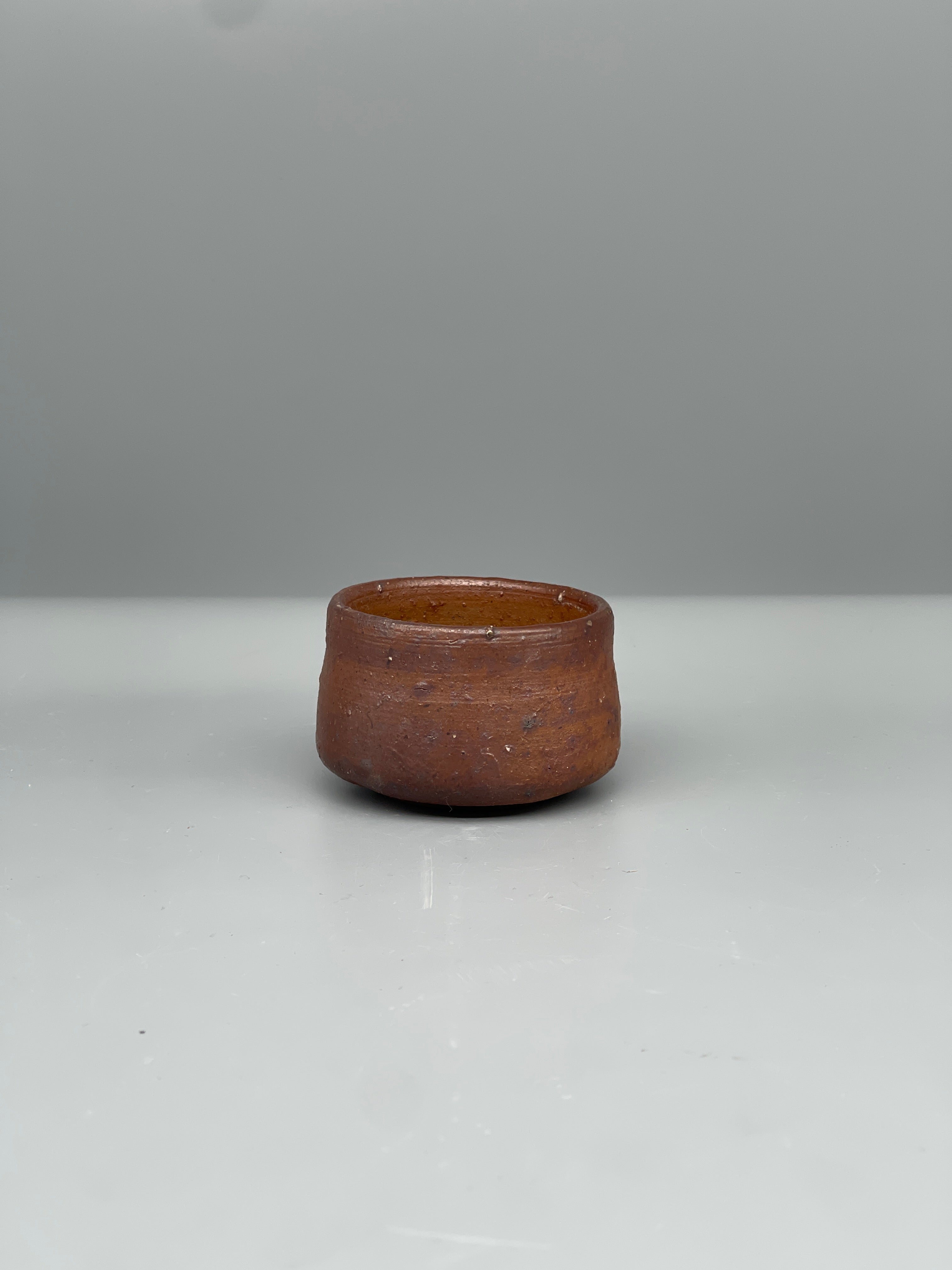 Vintage Japanese bizen guinomi cup, rust red, side view