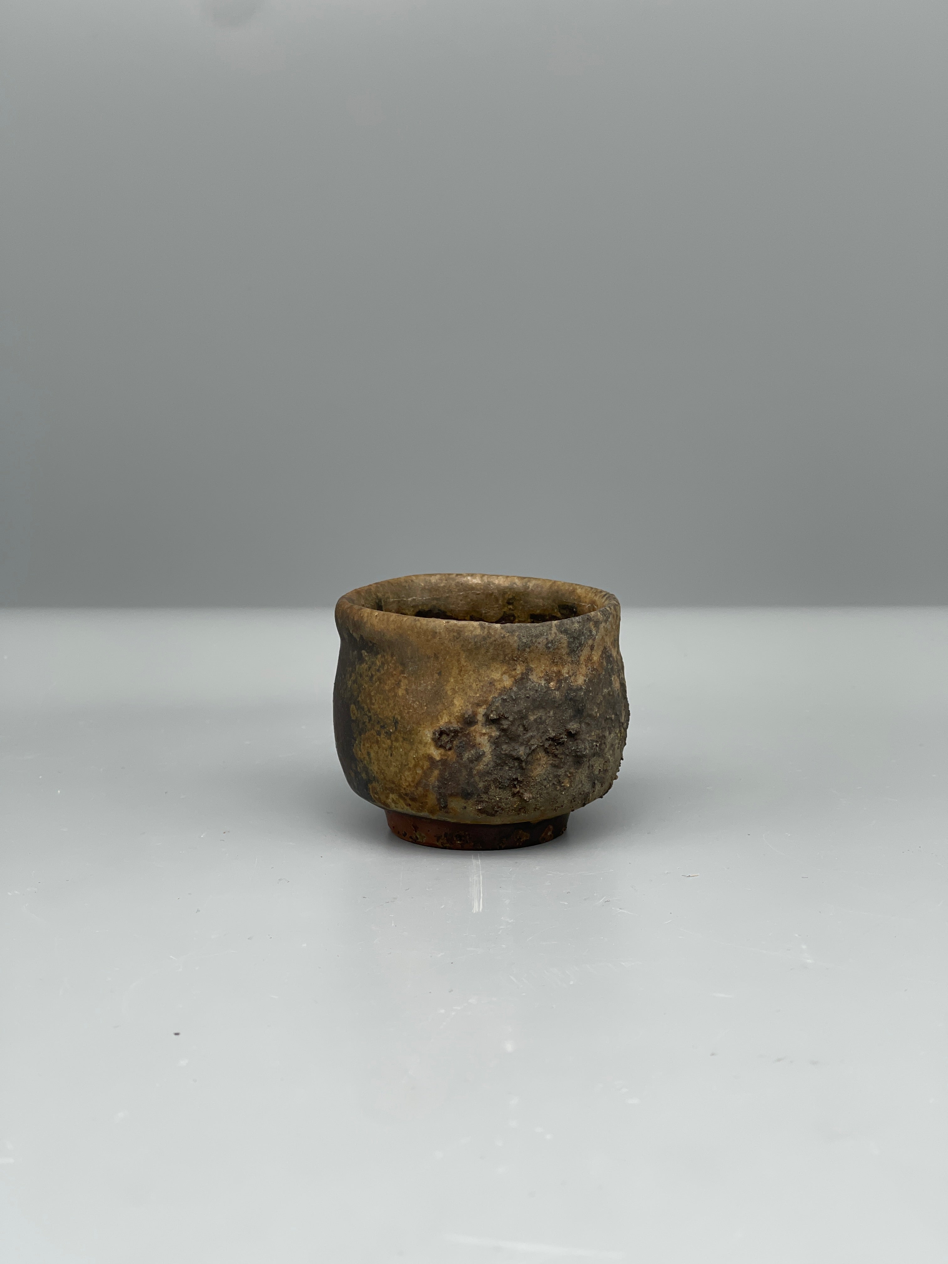 Vintage Japanese bizen guinomi cup, ash-crusted rim, side view