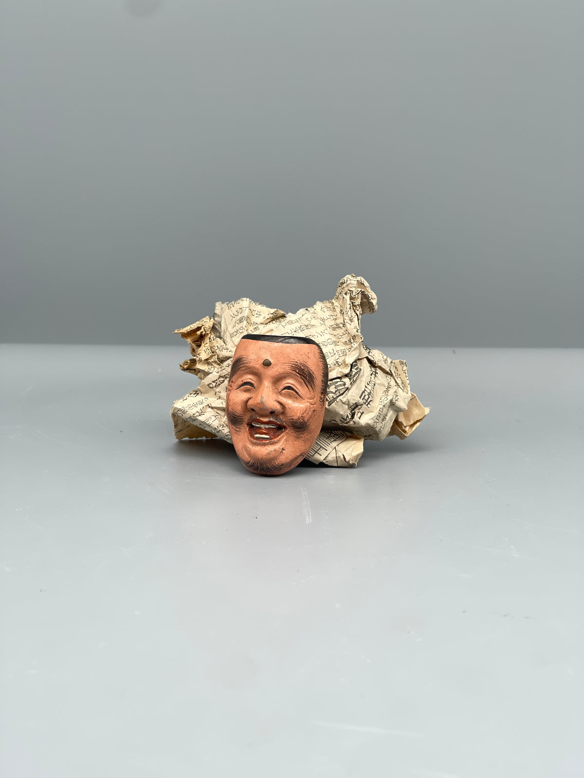 Vintage Japanese carved mask, smiling face, detail