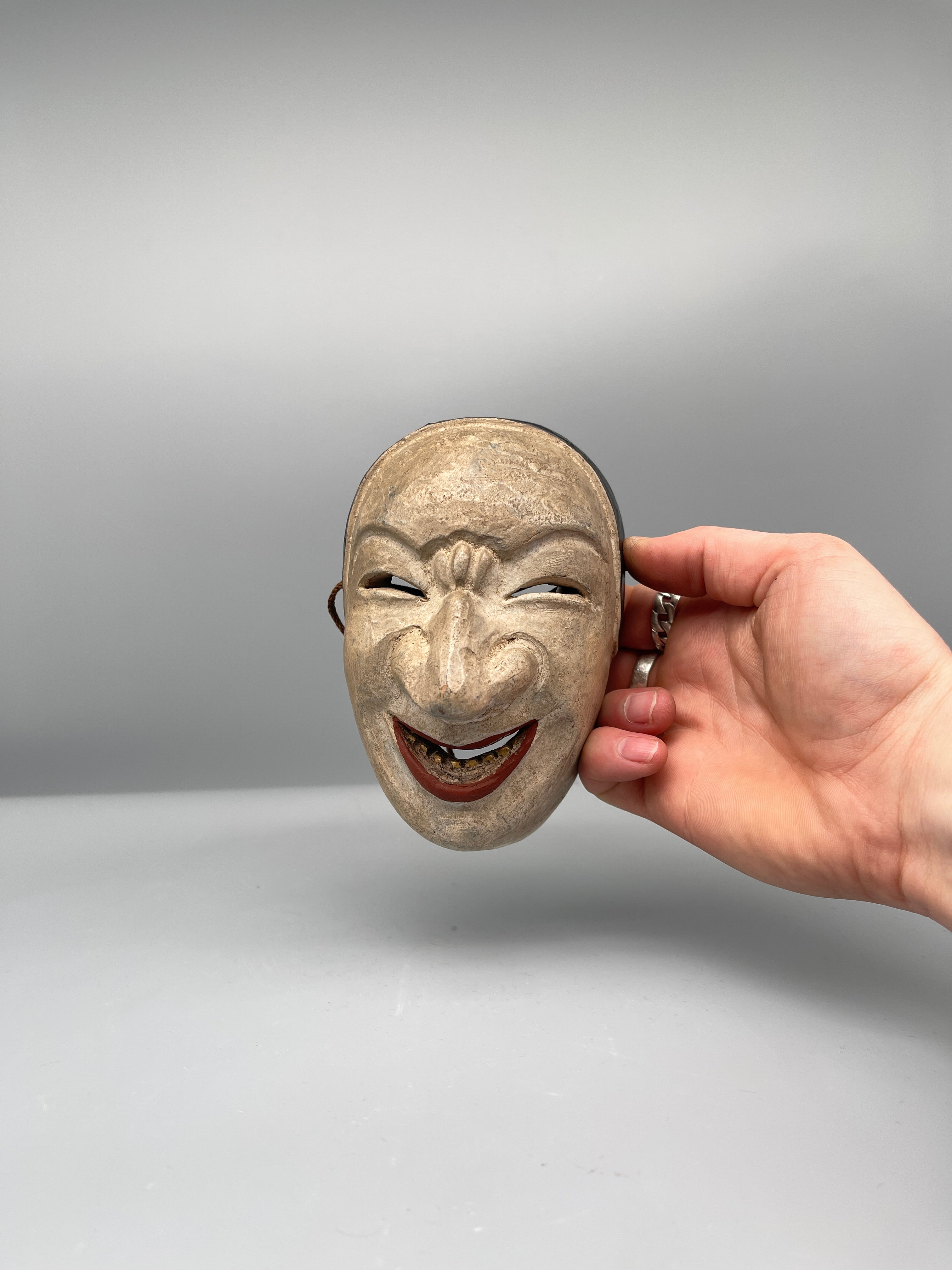 Vintage Japanese carved mask, aged finish, held view