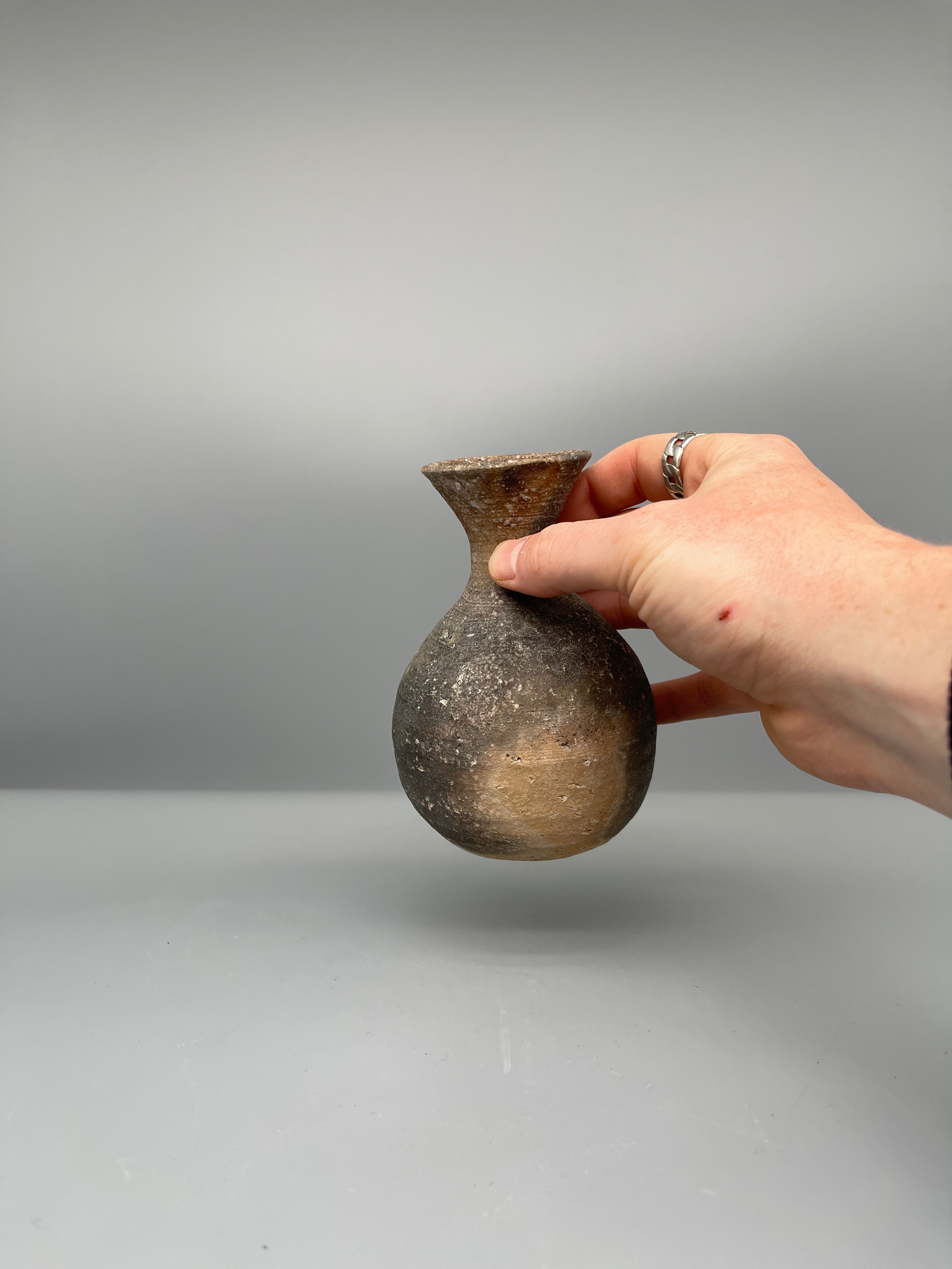 Vintage Japanese bizen flask, grey ash glaze, held for scale