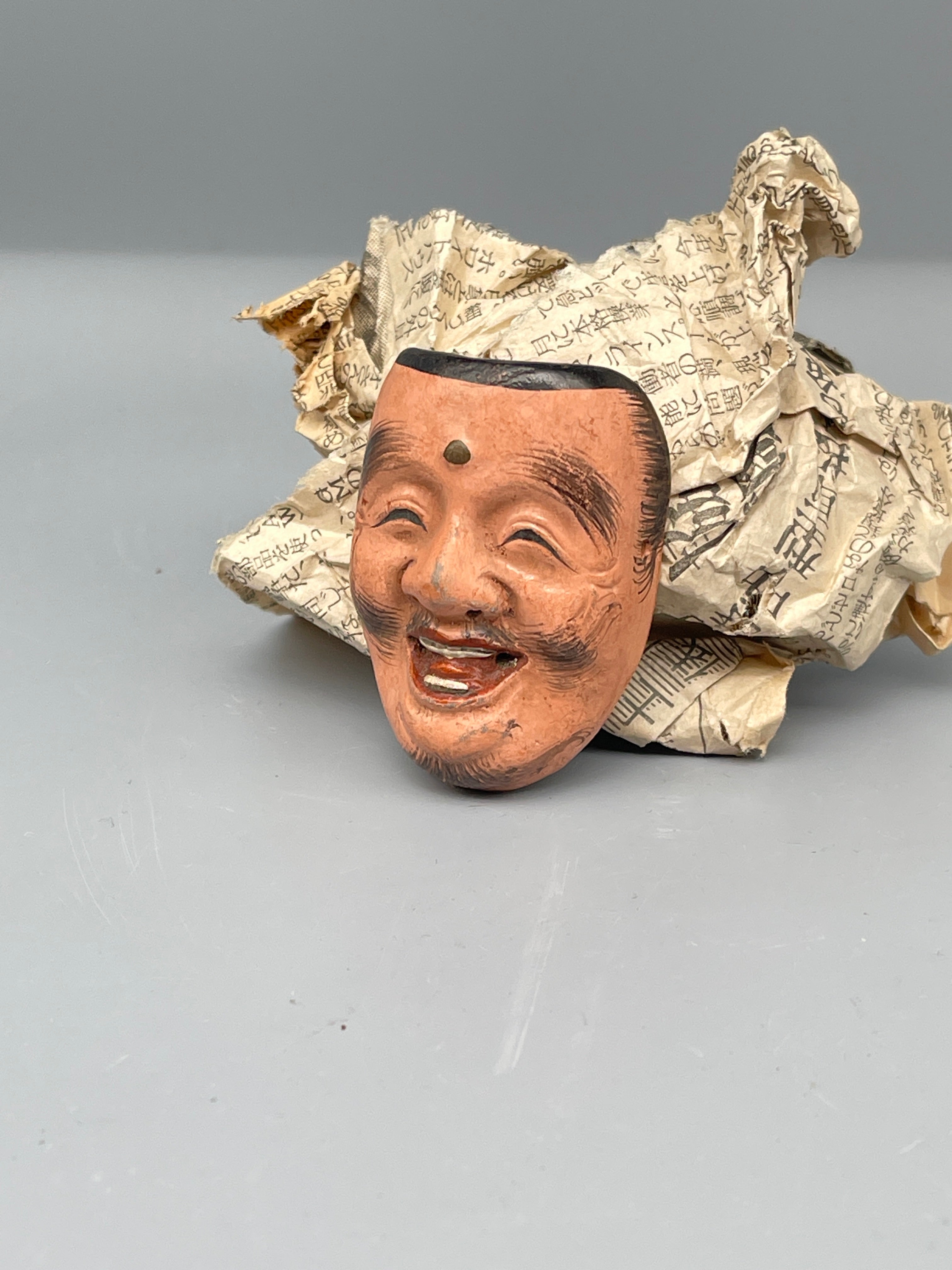 Vintage Japanese carved mask, smiling face, close up