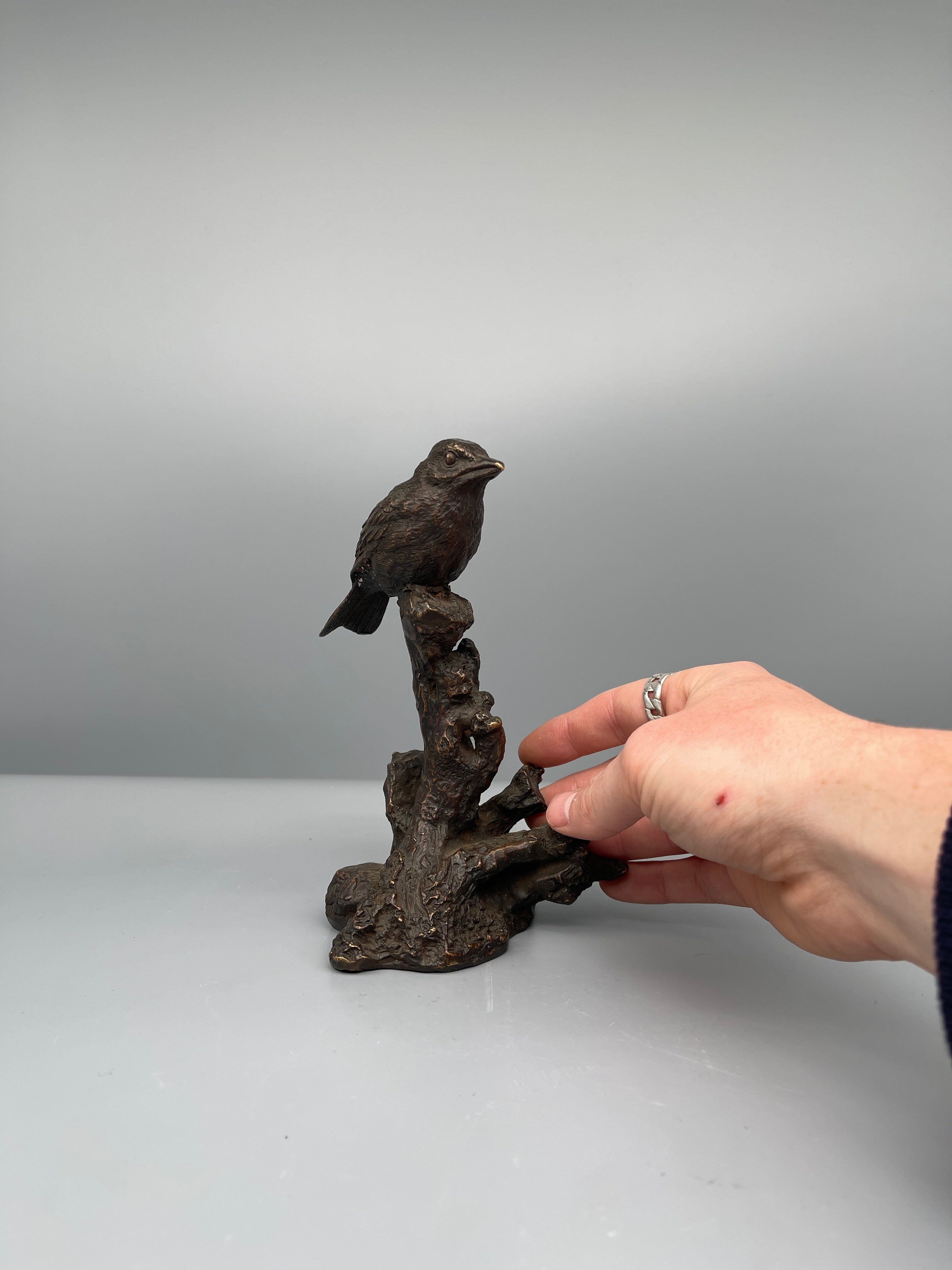 Vintage Japanese bronze bird figure, held for scale