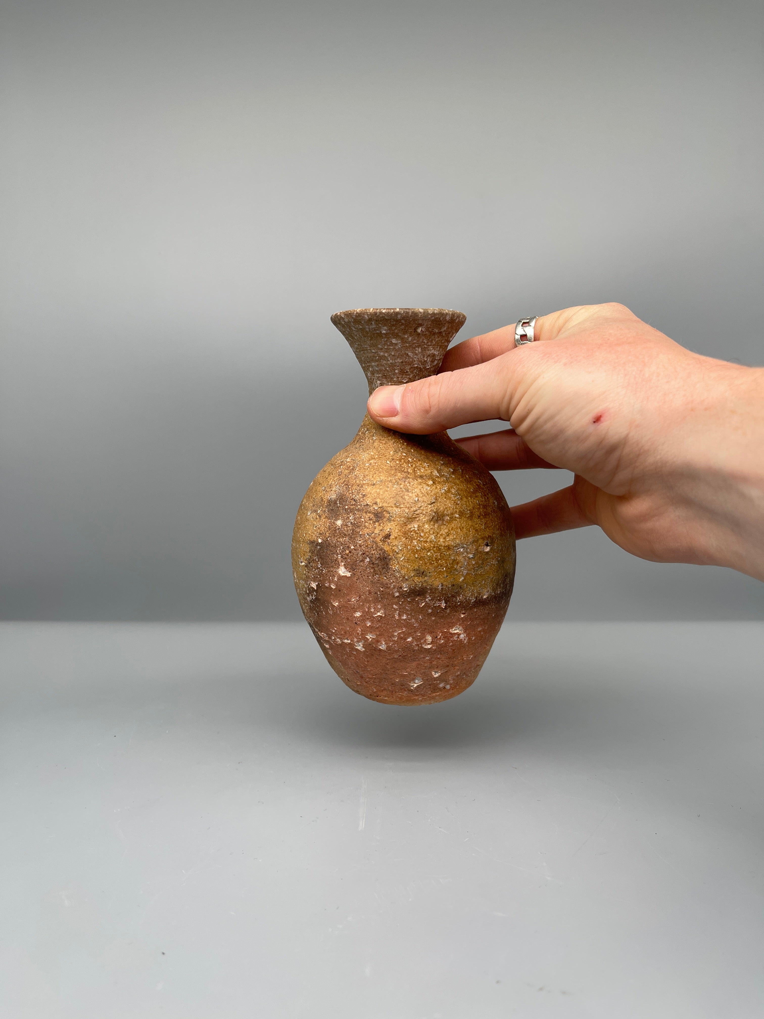 Vintage Japanese bizen flask, amber ash glaze, held for scale